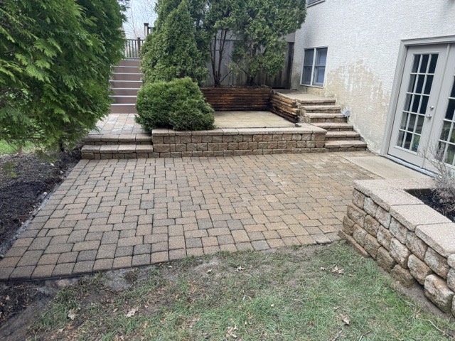 After: the same paver patio washed clean, joints re-sanded, and sealed with its color restored